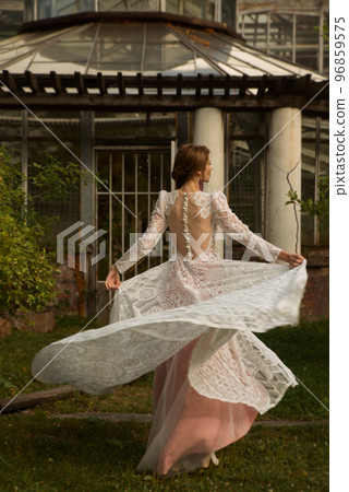 A young beautiful bride in a long boho wedding dress. A young beautiful bride in a long boho wedding dress. 96859575