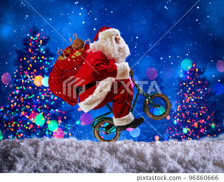Santaclaus wheelie with bike to deliver fast christmas gifts 96860666