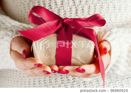 Woman holding box in craft paper. Color of the year 2023 - Viva Magenta 96860928