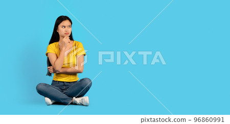 Serious pensive millennial korean lady student in yellow t-shirt sits on floor, look at empty space, thinks Serious pensive millennial korean lady student in yellow t-shirt sits on floor, look at empty space, thinks 96860991