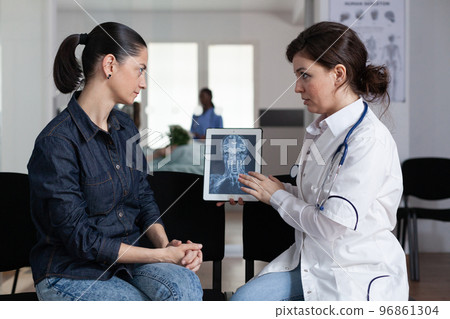 Medical laboratory worker delivering x ray images to young female patient. Medical surgeon explaining medical procedure to cure woman disease in medical clinic waiting room. 96861304