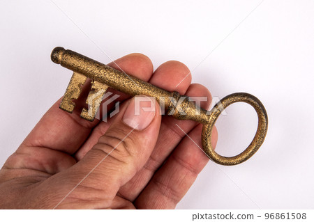 Gilded key in a man's hand. White background 96861508