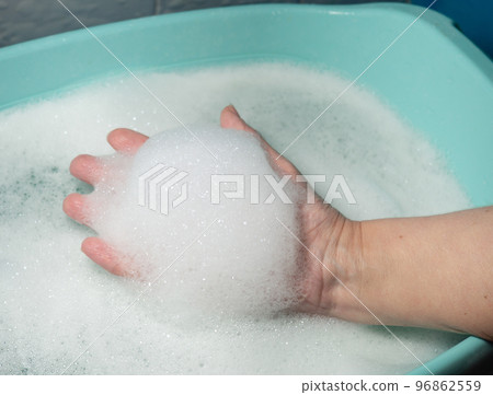 Foam in hand. Washing dishes. Washing basin. Foam in hand. Washing dishes. Washing basin. 96862559