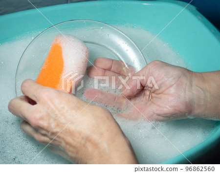 Hand washing dishes. Washing the plate with a foam sponge Hand washing dishes. Washing the plate with a foam sponge 96862560