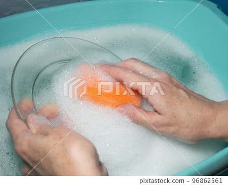 Washing dishes by hand. Washing the plate with a foam sponge. Washing dishes by hand. Washing the plate with a foam sponge. 96862561