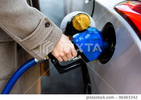 Korean man filling gas at gas station Korean man filling gas at gas station 96863342