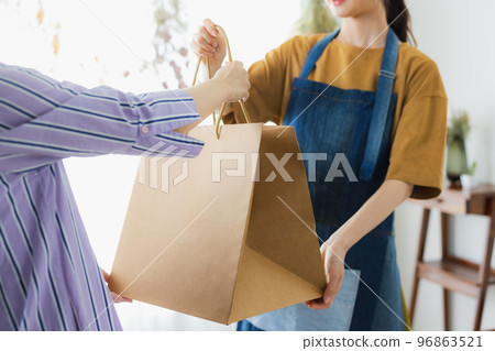 A woman in an apron serving customers A woman in an apron serving customers 96863521