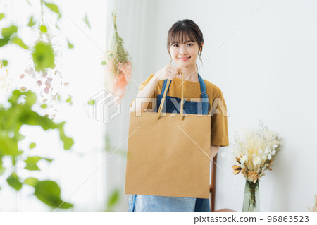 A woman in an apron serving customers A woman in an apron serving customers 96863523