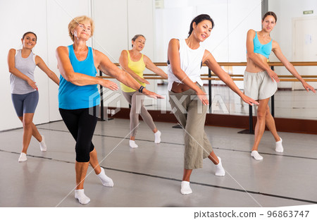 Group of active women practicing energetic dance in a studio Group of active women practicing energetic dance in a studio 96863747