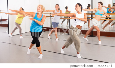 Group of active women practicing energetic dance in a studio Group of active women practicing energetic dance in a studio 96863781