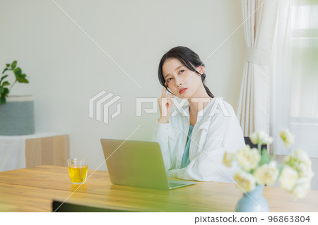 A woman looking at a computer in the living room 96863804