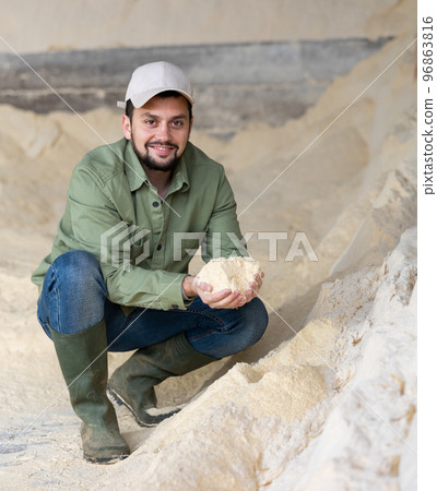Man farmer checking quality of maize flour 96863816