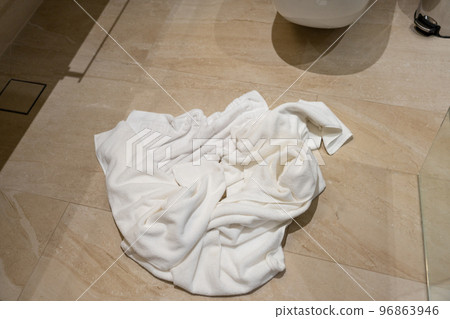 A pile of crumpled used towels on the bathroom floor A pile of crumpled used towels on the bathroom floor 96863946