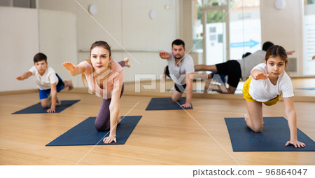Family of four practicing yoga at gym Family of four practicing yoga at gym 96864047