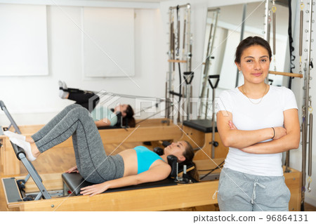 Hispanic young woman ready for training on pilates reformer Hispanic young woman ready for training on pilates reformer 96864131