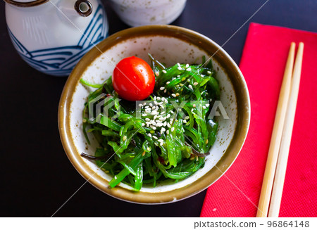 Wakame seaweed salad with sesame seeds and tomato in bowl 96864148