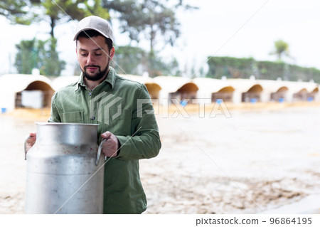 Man farmer standing with big milk can Man farmer standing with big milk can 96864195