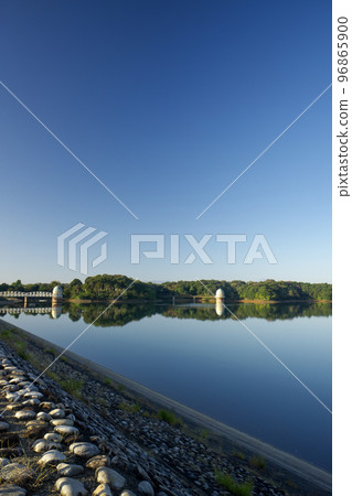 The lake surface and water intake tower of Lake Tama in the blue sky in autumn located on the Sayama Hills The lake surface and water intake tower of Lake Tama in the blue sky in autumn located on the Sayama Hills 96865900