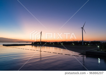 從新舞子精品橋（愛知縣知多市新舞子）看到的夕陽下的風力渦輪機 96866207