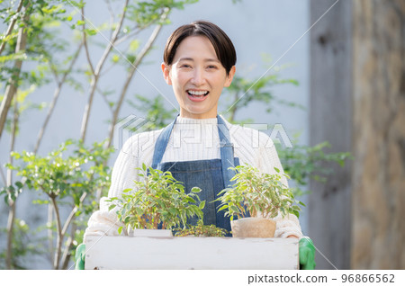 一位愛好園藝的女士和一位看著相機的店員的照片 96866562