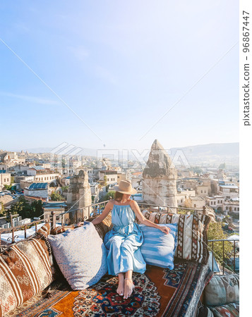 Young woman in dress on the roof with amazing view of Cappadocia in Turkey 96867447