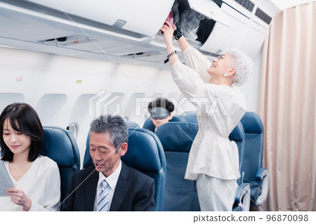 Passengers taking out carry-on luggage 96870098