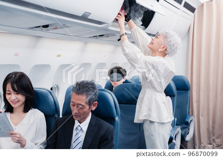 Passengers taking out carry-on luggage 96870099