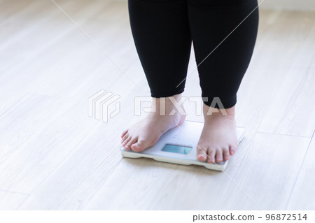 A woman's feet on a weight scale 96872514