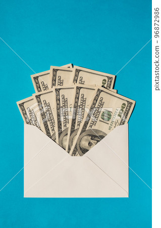 Dollar banknote saving money in envelope on blue background copy space. Consumption and economy Collecting money. Tips. Business, finance, saving, banking and people concept. Extra money, passive Dollar banknote saving money in envelope on blue background copy space. Consumption and economy Collecting money. Tips. Business, finance, saving, banking and people concept. Extra money, passive 96872986