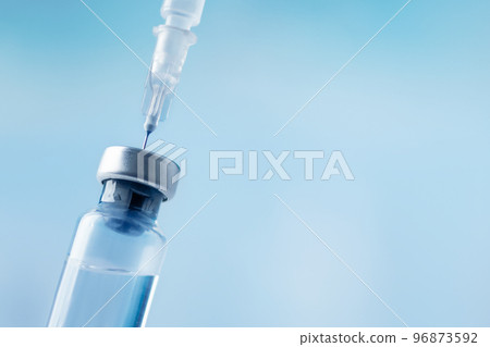 Glass vial and syringe with injection over blue background. Vaccination or beauty therapy concept. 96873592