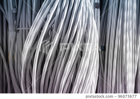 detail of large number of ethernet cables tied together connecting racks inside server room 96873677