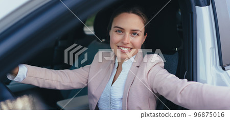Excited young woman sitting in her car, prepared for driving. Excited young woman sitting in her car, prepared for driving. 96875016
