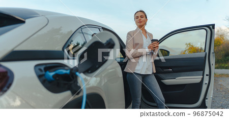 Young woman charging her electric car in home, sustainable and economic transportation concept. 96875042