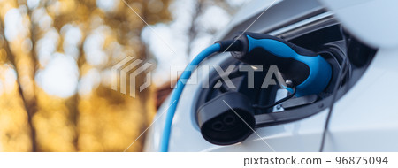 Charging an electric car,sustainable transportation concept.Low angle view. 96875094