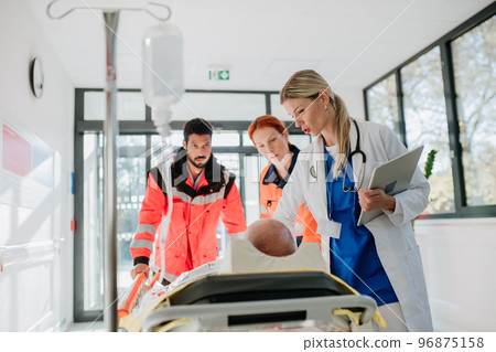 Young woman doctor taking care of patient from rescue ambulance. Young woman doctor taking care of patient from rescue ambulance. 96875158