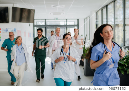 Young stressed doctors running at hospital corridor. Young stressed doctors running at hospital corridor. 96875162