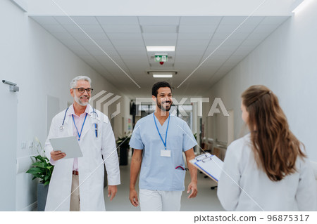 Team of doctors meeting at hospital corridor. Team of doctors meeting at hospital corridor. 96875317