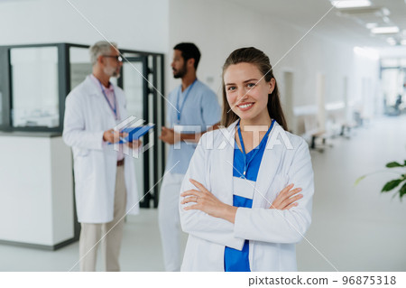 Portrait of young woman doctor at hospital corridor. Portrait of young woman doctor at hospital corridor. 96875318