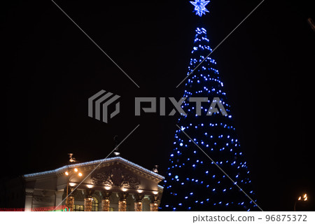 City Gomel Drama Theatre with Christmas illumination and festive Christmas tree on the square 96875372