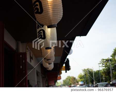 Japanese lantern hung in front of Japanese Restaurant, Japanese text on lantern is "Sushi" Japanese food. Japanese lantern hung in front of Japanese Restaurant, Japanese text on lantern is "Sushi" Japanese food. 96876957