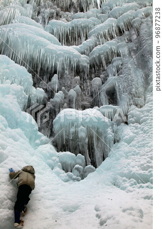 男孩爬上結冰的瀑布 男孩爬上結冰的瀑布 96877238