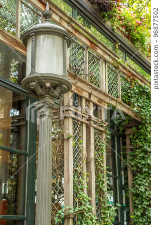 Old lamp and an ivy covered entrance to a building. Old lamp and an ivy covered entrance to a building. 96877502