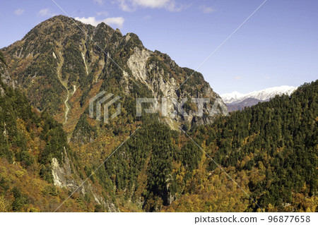 A rocky mountain covered in autumn leaves 96877658