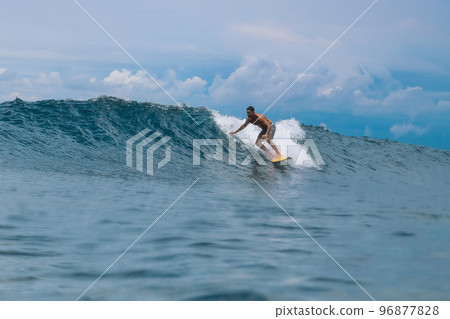Shirtless male surfer on a wave at sunny day Shirtless male surfer on a wave at sunny day 96877828