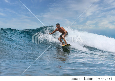 Shirtless male surfer on a wave at sunny day Shirtless male surfer on a wave at sunny day 96877831