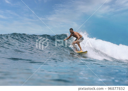 Shirtless male surfer on a wave at sunny day Shirtless male surfer on a wave at sunny day 96877832