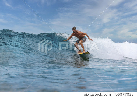 Shirtless male surfer on a wave at sunny day Shirtless male surfer on a wave at sunny day 96877833