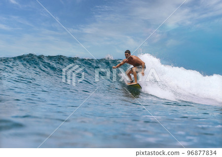 Shirtless male surfer on a wave at sunny day Shirtless male surfer on a wave at sunny day 96877834