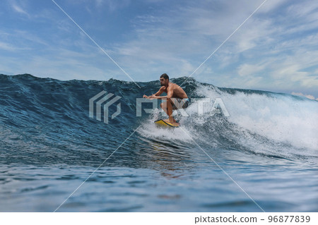 Shirtless male surfer on a wave at sunny day 96877839