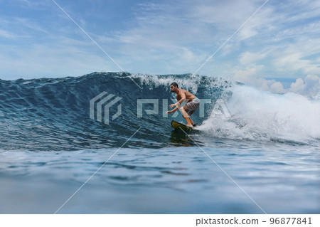 Shirtless male surfer on a wave at sunny day Shirtless male surfer on a wave at sunny day 96877841